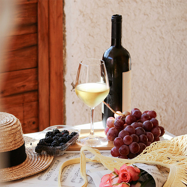 Weinflasche mit Weißwein, Trauben und Snacks